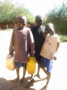 Child workers share a happy moment at the water tap.