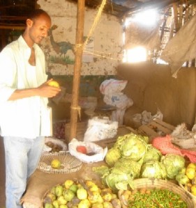 A refugee surveys vegetables in the camp market.